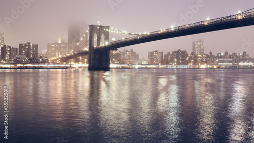 Brooklyn Bridge on a foggy night, color toned picture, New York City, USA.