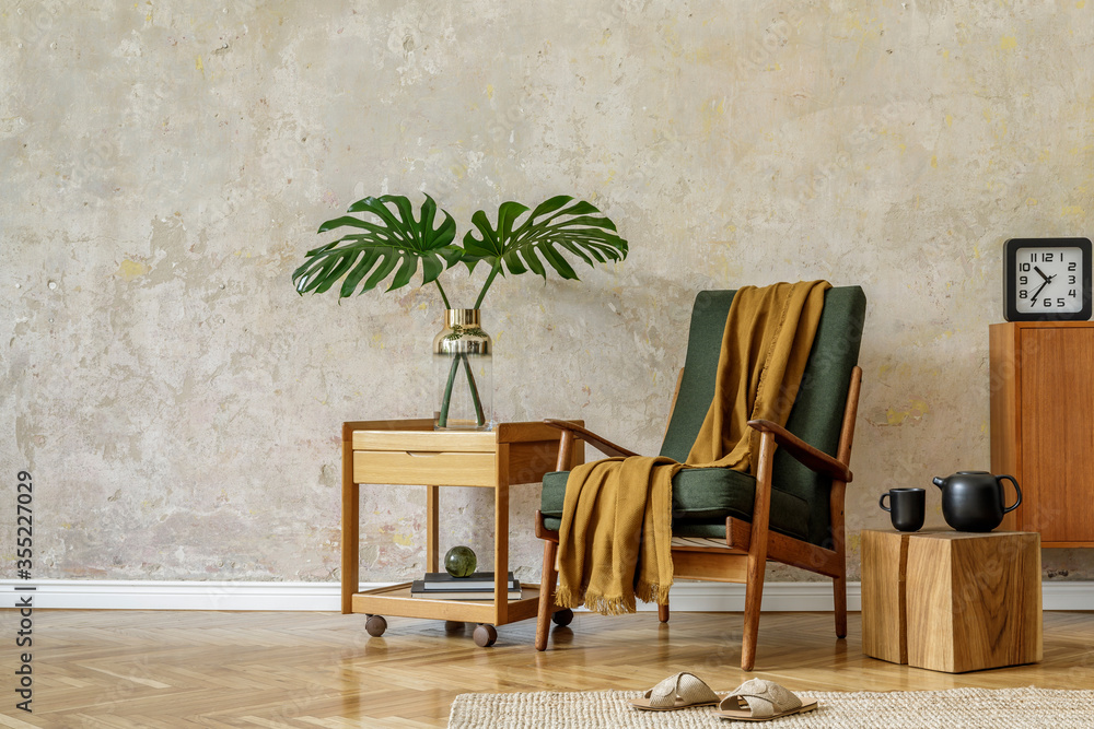 Obraz premium Modern retro composition of living room interior with design armchair, cube, tea pot on the tray, tropical leaf, plaid, carpet, decoration and elegant presonal accessories in wabi sabi concept.
