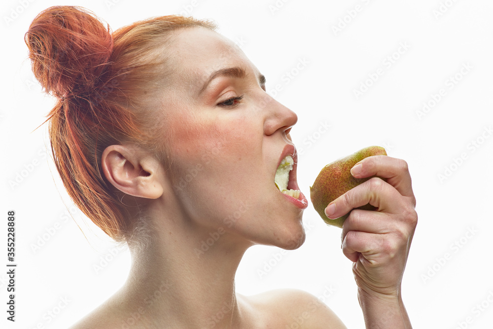 Portrait of a young redhead girl with a red and green pear in her hands, with different emotions. Isolated on a white background. Portrait of a young redhead girl with a red and green pear in her hands, with different emotions. Isolated on a white background.