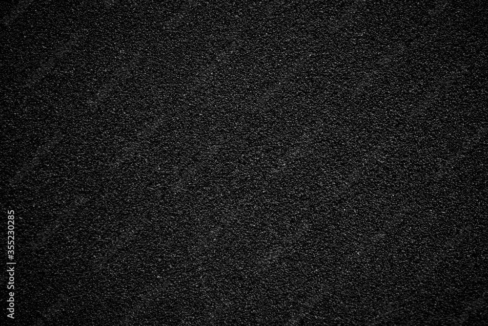 Fine-grained black-gray texture with focus in the center of the frame and above, blurring and darkening of the background at the edges Fine-grained black-gray texture with focus in the center of the frame and above, blurring and darkening of the background at the edges