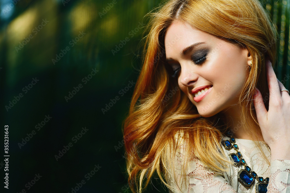 Naklejka premium portrait of a beautiful girl with a smile in the sun