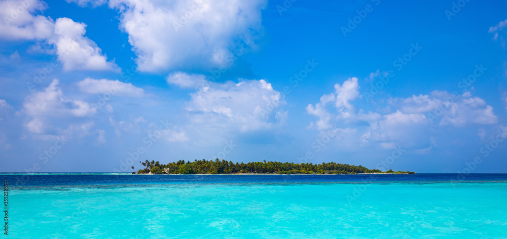 tropical island, palm trees and turquoise sea under a blue sky with white clouds