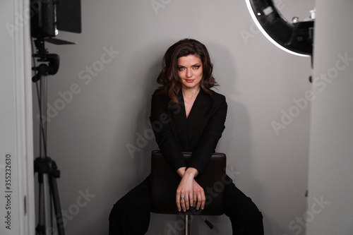 Fotografie Young beautiful sexy model in black suit posing in photo studio