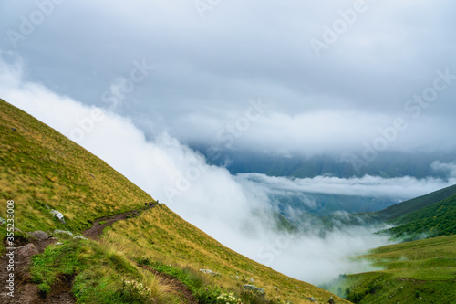 Kazbegi, Georgia - Mountain landscape of Mount Kazbegi landscape with dramatic clouds up in the trekking and hiking route.