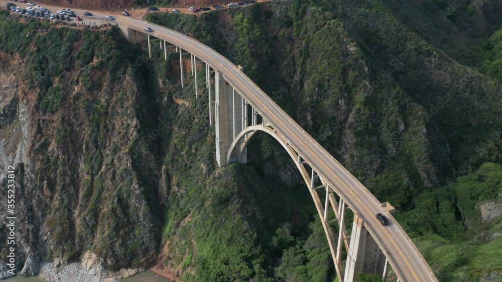 Cinematic 4K aerial of vehicles crossing the narrow bridge over the steep deep canyon. Drone video of amazing nature with sheer ocean cliffs of the Big Sur State Park, Pacific coast California, USA Cinematic 4K aerial of vehicles crossing the narrow bridge over the steep deep canyon. Drone video of amazing nature with sheer ocean cliffs of the Big Sur State Park, Pacific coast California, USA