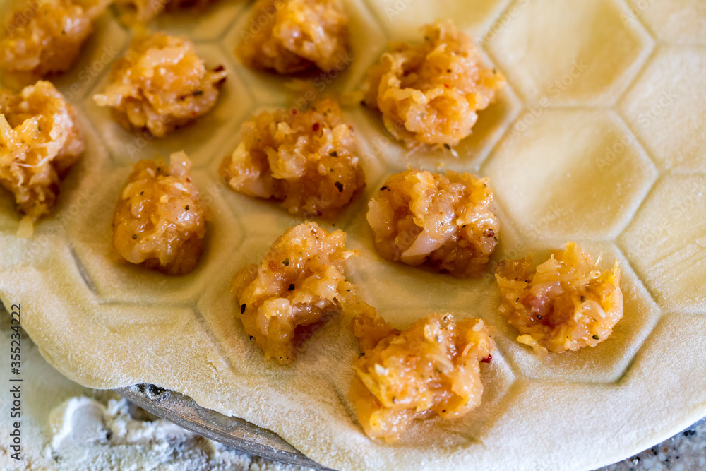 Raw homemade dumplings. Chicken meat with spices on the dough. The process of making dumplings Raw homemade dumplings. Chicken meat with spices on the dough. The process of making dumplings