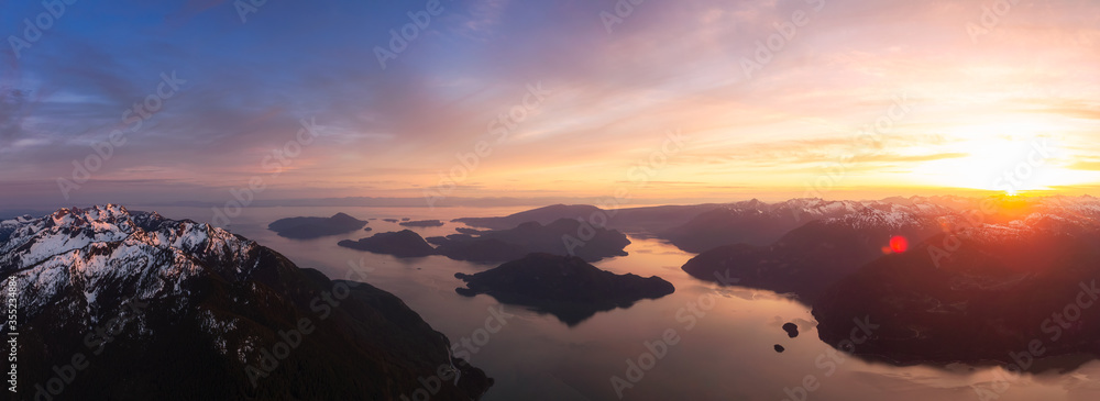 Aerial Panoramic View of Canadian Mountain Landscape, Howe Sound, during a colorful sunset. Taken near Squamish and Vancouver, British Columbia, Canada. Nature Background Panorama