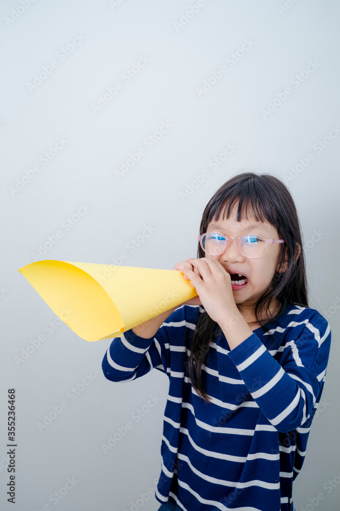 Lettle girl shouting into megaphone with white background. Lettle girl shouting into megaphone with white background.