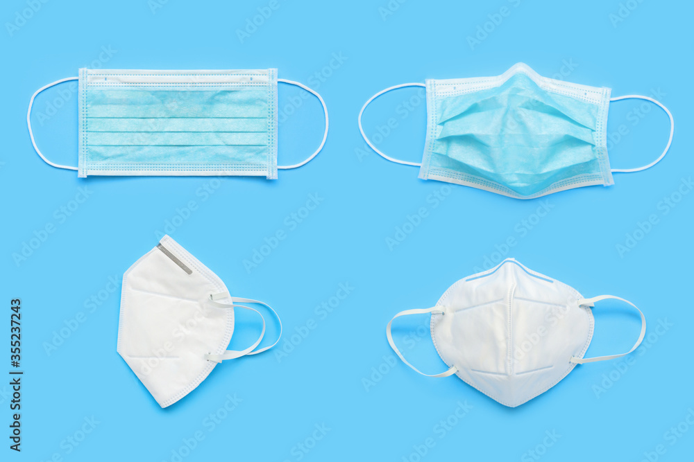 KN95 and surgical face mask on blue background protection against pm 2.5 polution and COVID-19 coronavirus. Healthcare and medical concept KN95 and surgical face mask on blue background protection against pm 2.5 polution and COVID-19 coronavirus. Healthcare and medical concept