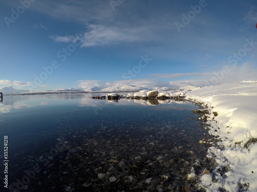 deep blue ocean landscape with snowy mountain and sunshine