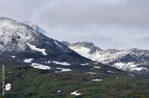 new fresh white snow on jagged mountain top in the arctic circle summer