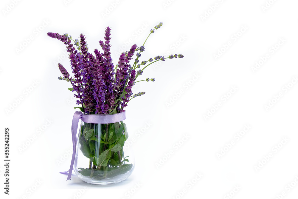 Lilac flowers with green leaves in a vase on a white background