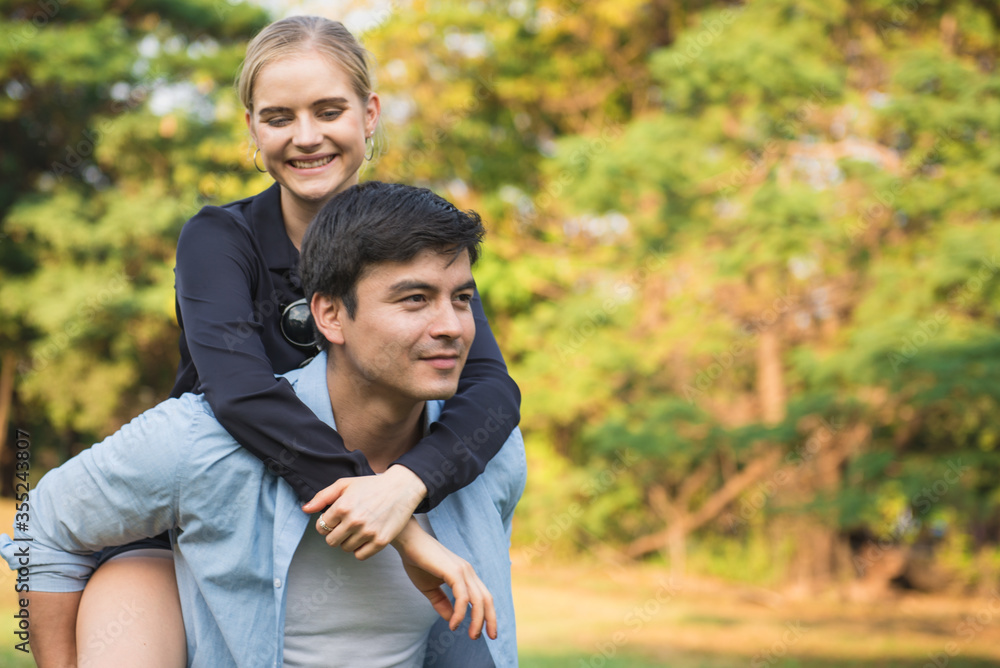 Cheerful man giving piggyback ride to woman Cheerful man giving piggyback ride to woman