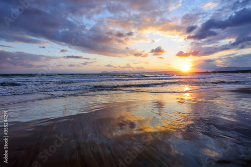Unbelievable sunrise. Beautiful summertime view seascape. The wet sand on the sea coast. Morning landscape. High waves with foam. Romantic relax places. Location place island Crete, Greece.