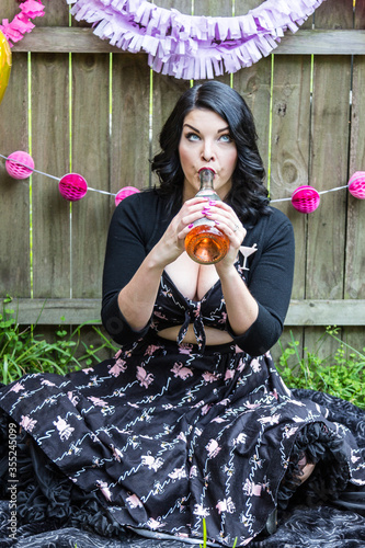 Young woman drinks champagne to celebrate