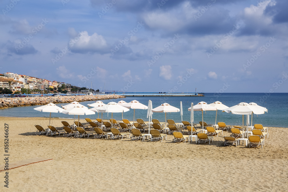 Desert beach with deck chairs and umbrellas waiting for tourists after quarantine. Fantastic white sand, sea and mountain. 2020 summer travel. Relax places island Crete, Greece. Desert beach with deck chairs and umbrellas waiting for tourists after quarantine. Fantastic white sand, sea and mountain. 2020 summer travel. Relax places island Crete, Greece.