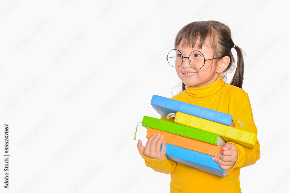 Asian little girl holding stack books on white background Back to school, education, elementary school concept Asian little girl holding stack books on white background Back to school, education, elementary school concept