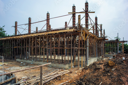 Perspective of house structure under construction at site with blue sky background