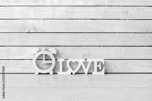 Clock Shaped with Love Alphabet on white wood over white wood background