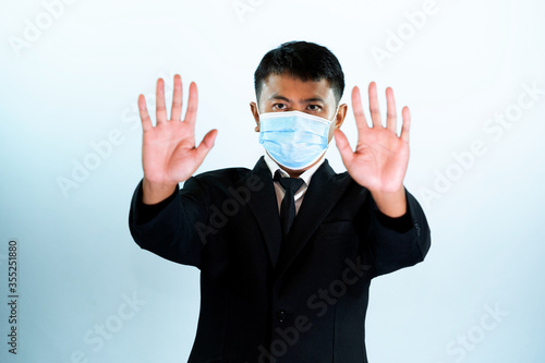 Business people wearing protective mask raise hands to stop the Covid-19,Corona virus pandemic warning of risk in real estate financing or investing in asset valuable and quality concept.