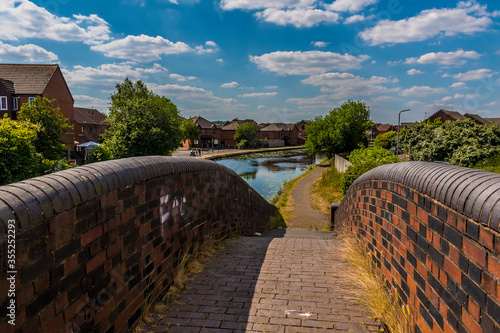 A view down the towpath towards residential properties beside the Birmingham Canal in summertime photo