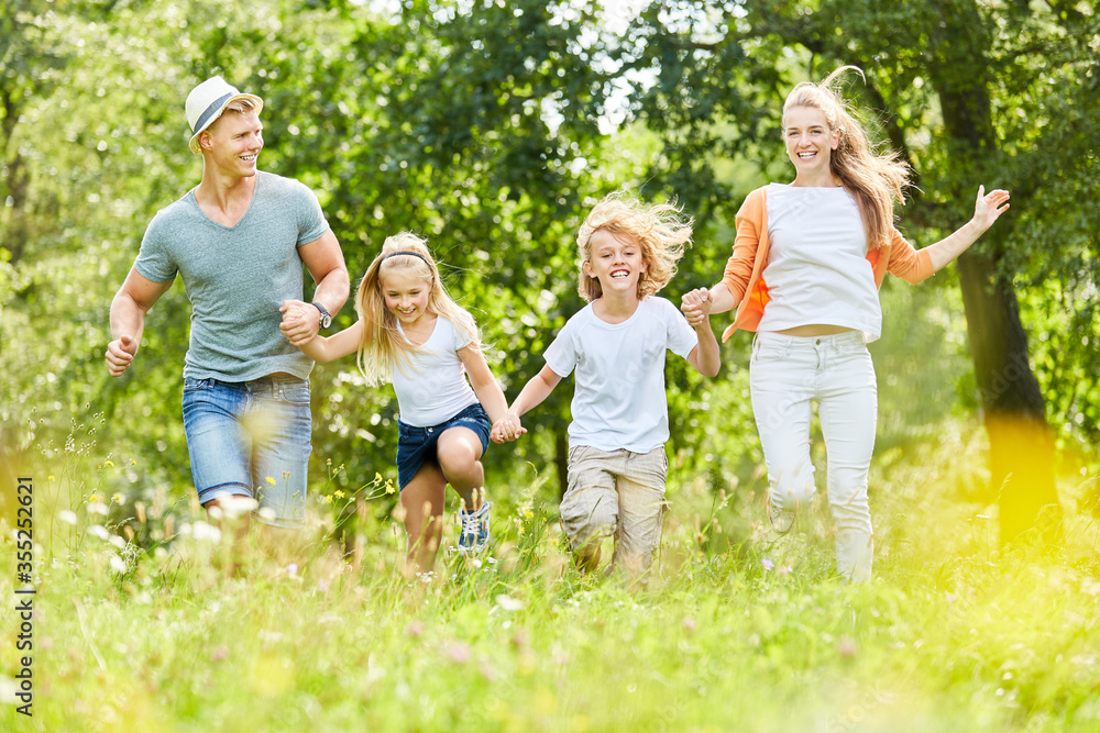 Familie und Kinder laufen über eine Wiese Familie und Kinder laufen über eine Wiese