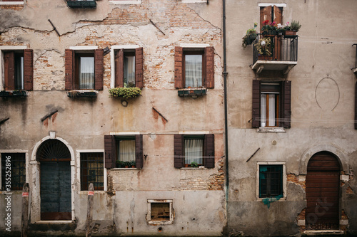 A very old building in Europe with windows, a balcony and doors. Beautiful wall for the background. 