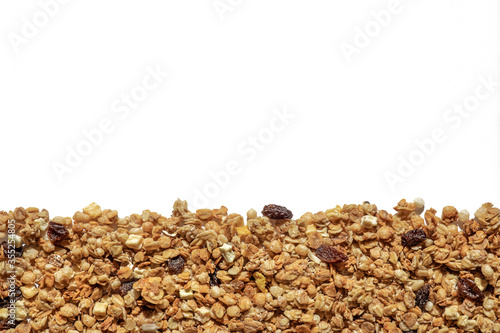 granola on a white background, cereal and raisin texture close-up top view, healthy breakfast concept,