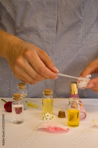 Beautiful and useful photo of a woman who makes homemade natural cosmetics and lipsticks from oils, essential oils, peppermint, rose water and aloe vera gel