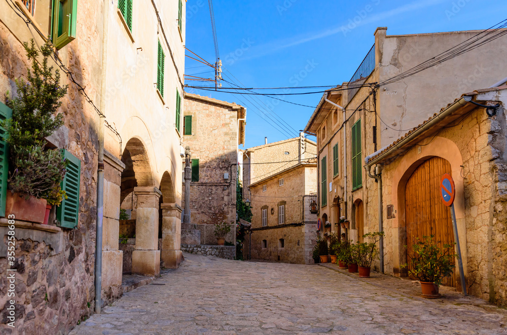 Colorful street with stone buildings in the old town of Valldemossa, Mallorca island, Spain