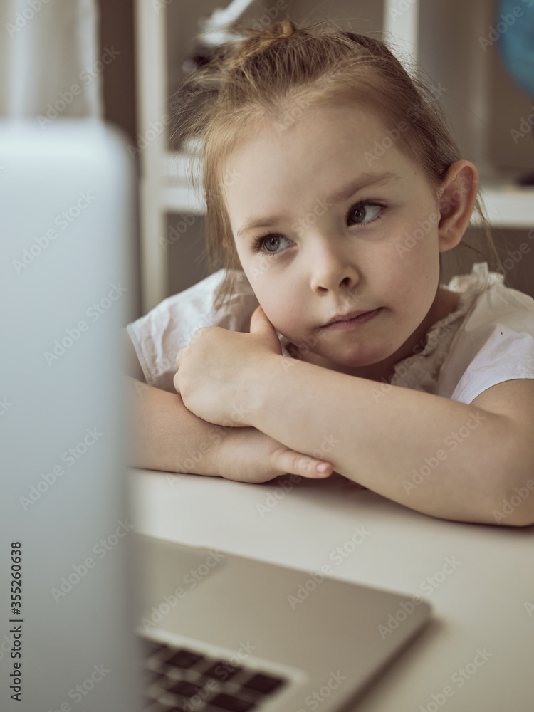Cute little girl using laptop at home. Education, online study, home studying The girl at home communicates with friends on the Internet. Kids distance learning. High quality photo Cute little girl using laptop at home. Education, online study, home studying The girl at home communicates with friends on the Internet. Kids distance learning. High quality photo