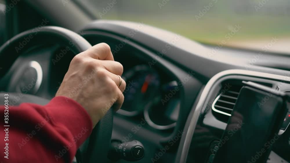 Male hand is on the wheel of the car clear by day. Male hand is on the wheel of the car clear by day.