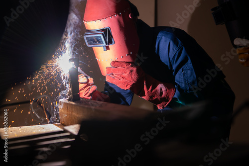 Metal welding steel works using electric arc welding machine to weld steel at factory. Metalwork manufacturing and construction maintenance service by manual skill labor concept. photo