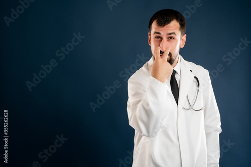 Male doctor with stethoscope in medical uniform doing look into my eyes or pay attention at me gesture