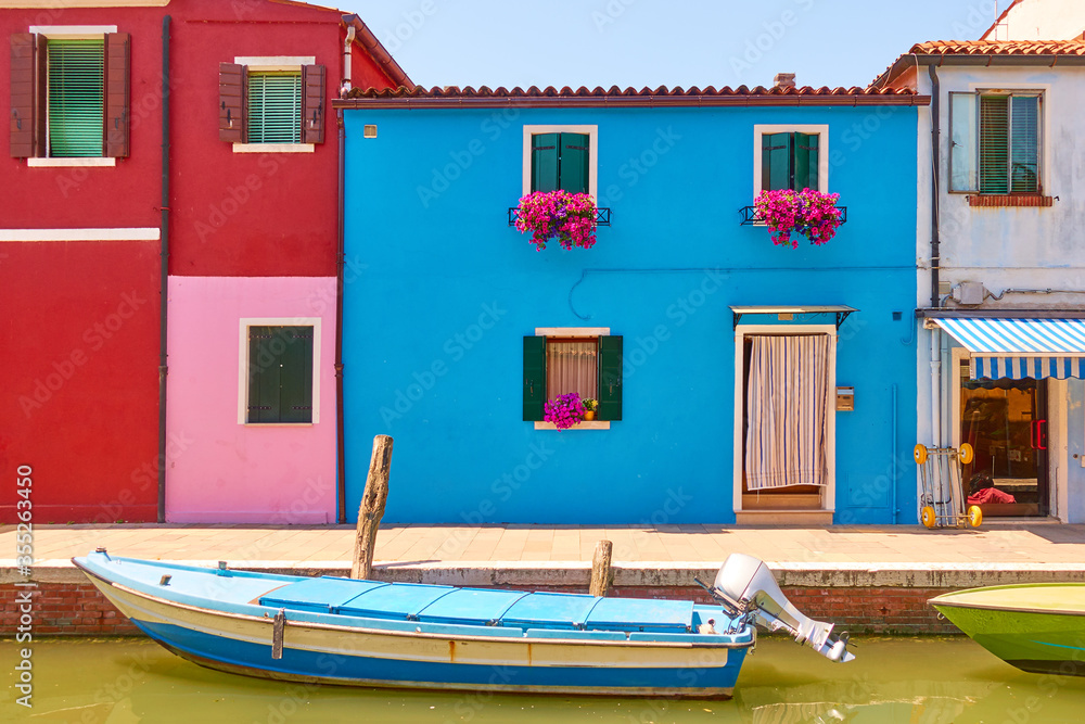 Canal with boats and colorful houses in Burano in Venice