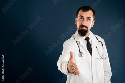 Male doctor with stethoscope in medical uniform shaking hand
