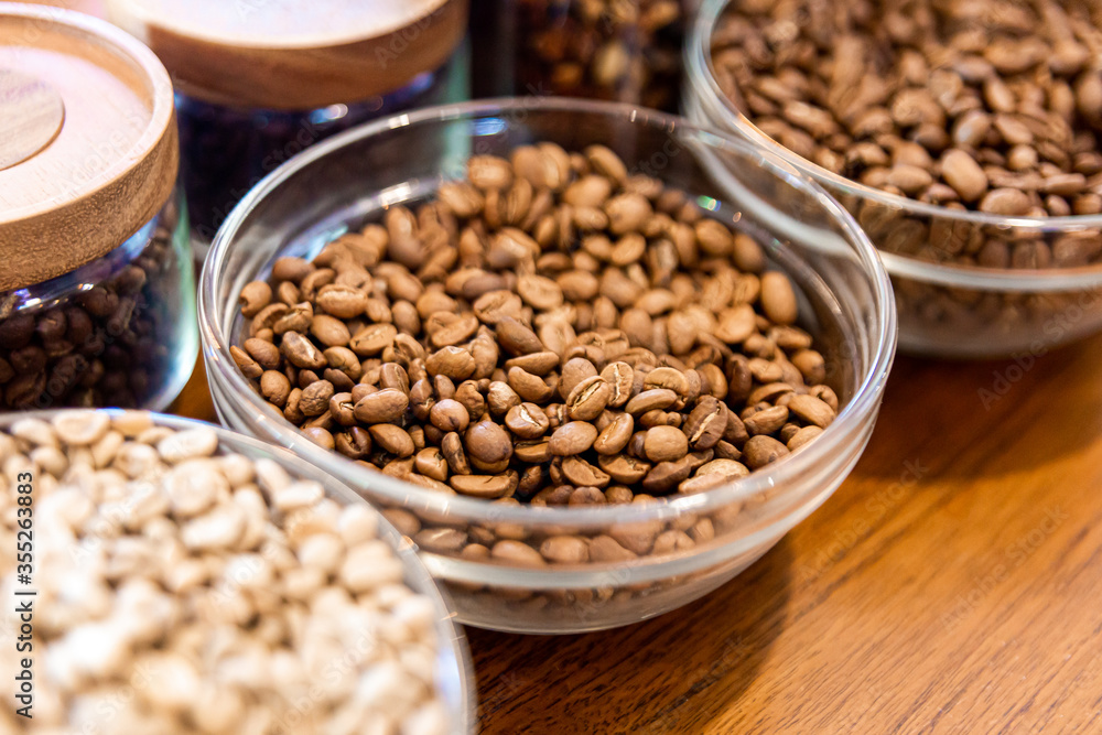 Coffee beans in a glass bowl on a wooden table in coffee shop Coffee beans in a glass bowl on a wooden table in coffee shop