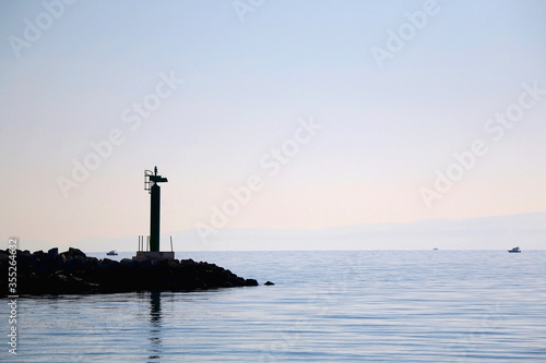 Silhouette of a small lighthouse on a pier in Split, Croatia. © jelena990