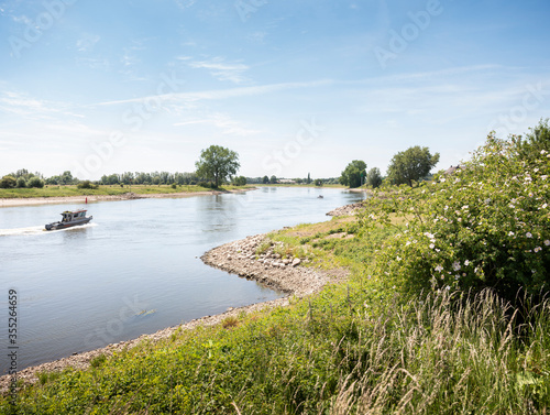 boat on river ijssel between deventer and zutphen on sunny summer day photo