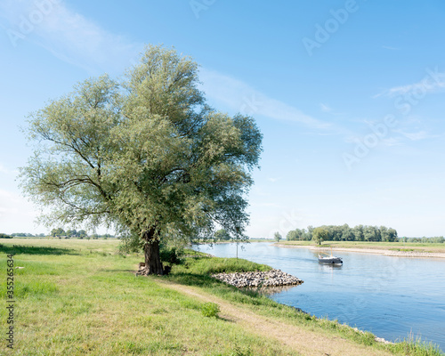 boat on river ijssel between arnhem and zutphen on sunny summer day photo