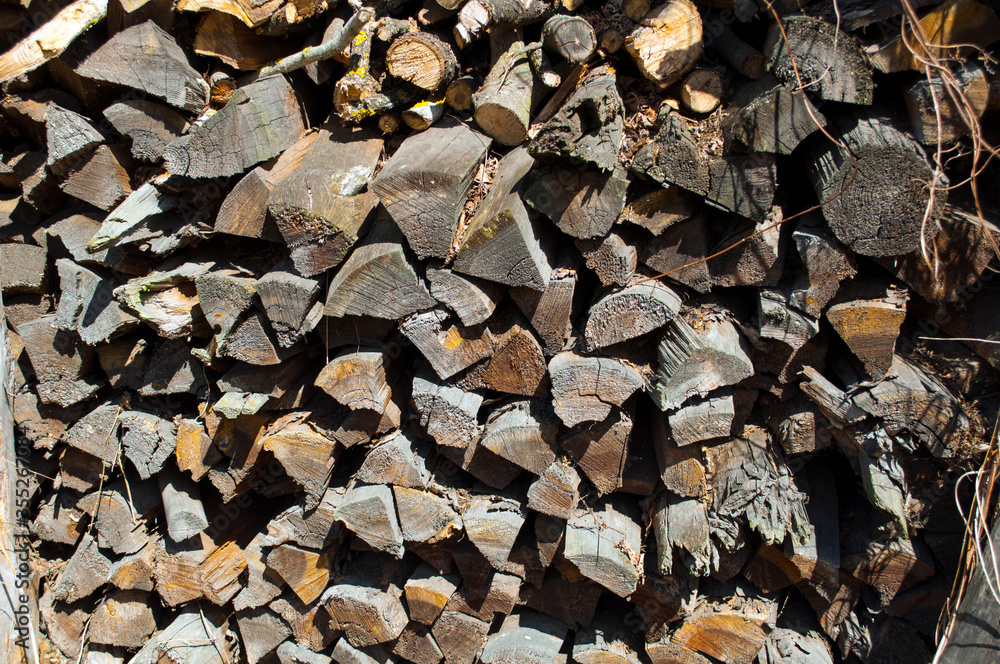 Stacked old rotten gray firewood, stocks. Background, texture, sunny day. Stacked old rotten gray firewood, stocks. Background, texture, sunny day.