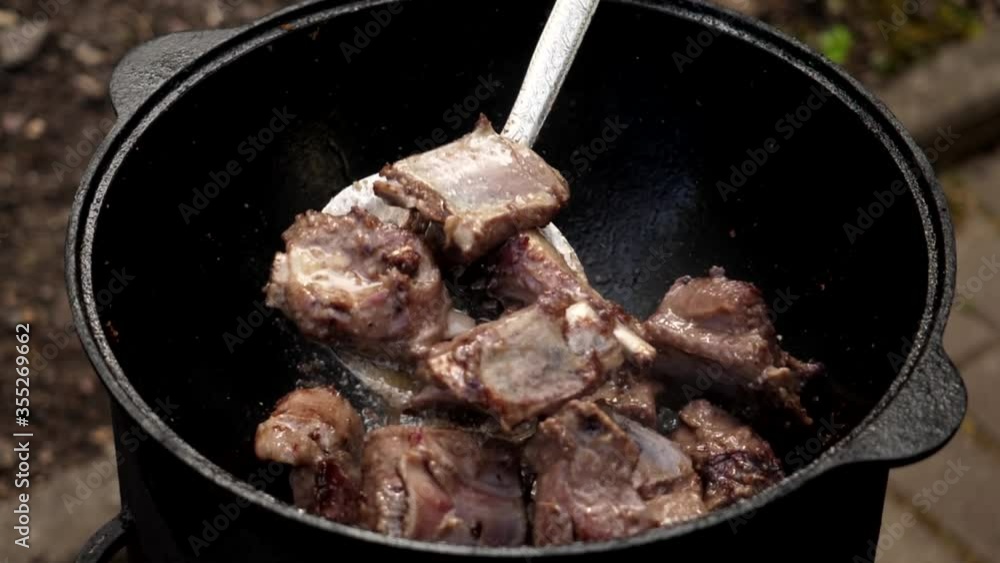 A man cooks fried meat in a pan with sauce and beer. 4K shooting A man cooks fried meat in a pan with sauce and beer. 4K shooting