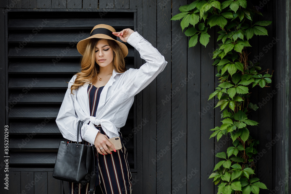 Fashion woman portrait of young pretty trendy girl posing at the city in Europe