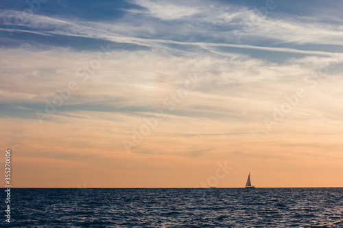 A beautiful sky with a boat in the sea with clouds over