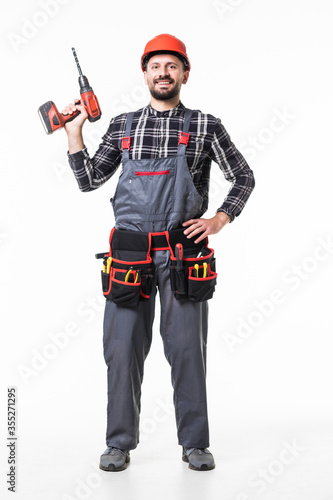 Handsome builder in uniform with tool belt holding drill isolated on white background © F8  \ Suport Ukraine