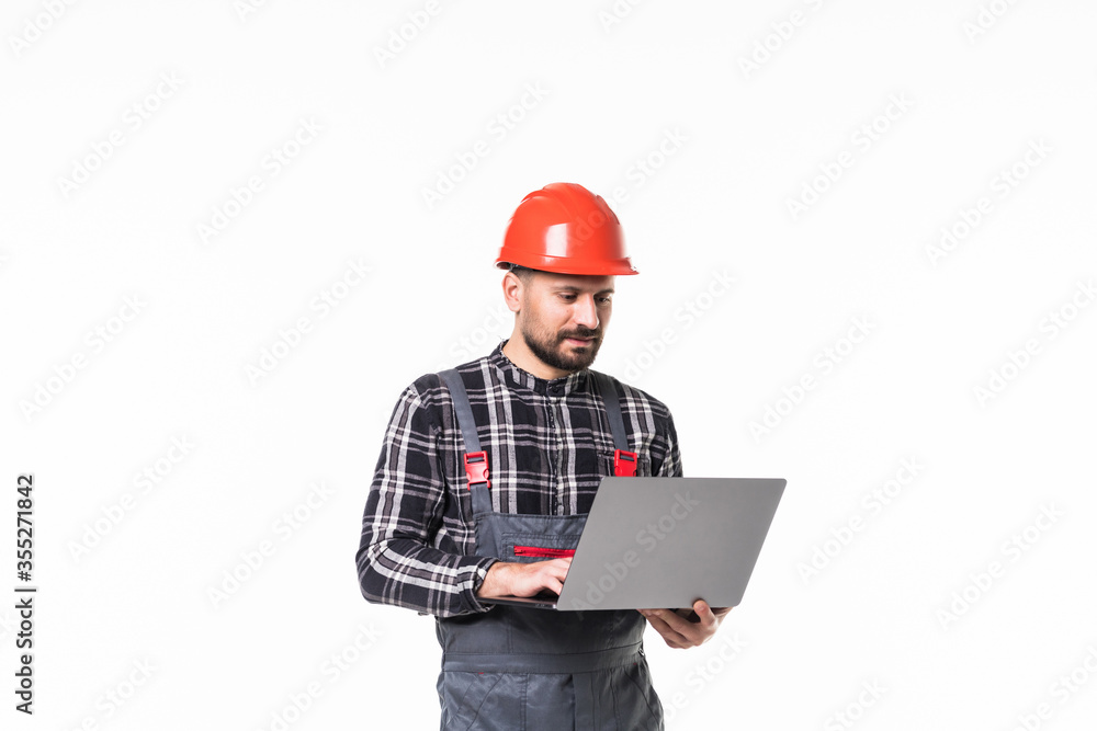 Repairman in hemlet using laptop against white background Repairman in hemlet using laptop against white background