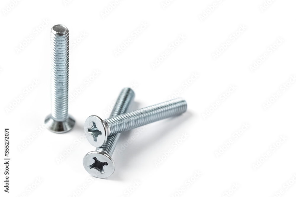 Screw nuts on a white background with copy space. Stainless screws, bolts for construction Screw nuts on a white background with copy space. Stainless screws, bolts for construction