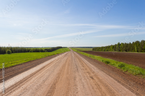 Country road on a bright sunny day. A countryside with field view