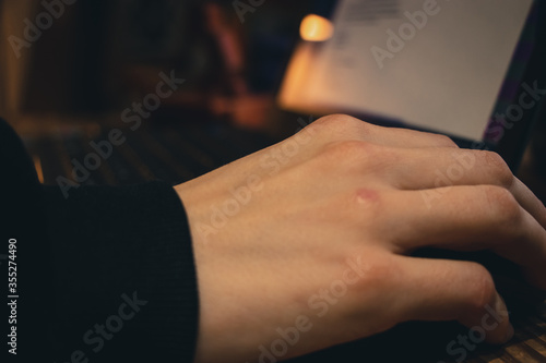 Hands of a woman working in a laptop at home