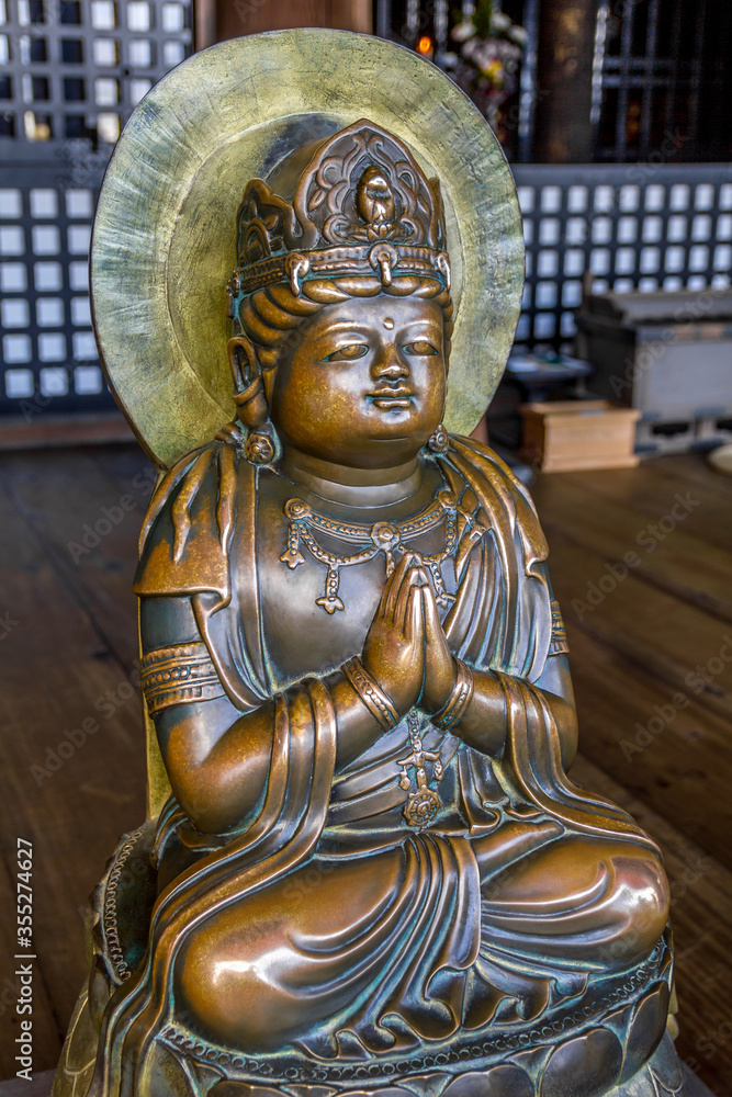 Statue of a Buddha praying in bronze